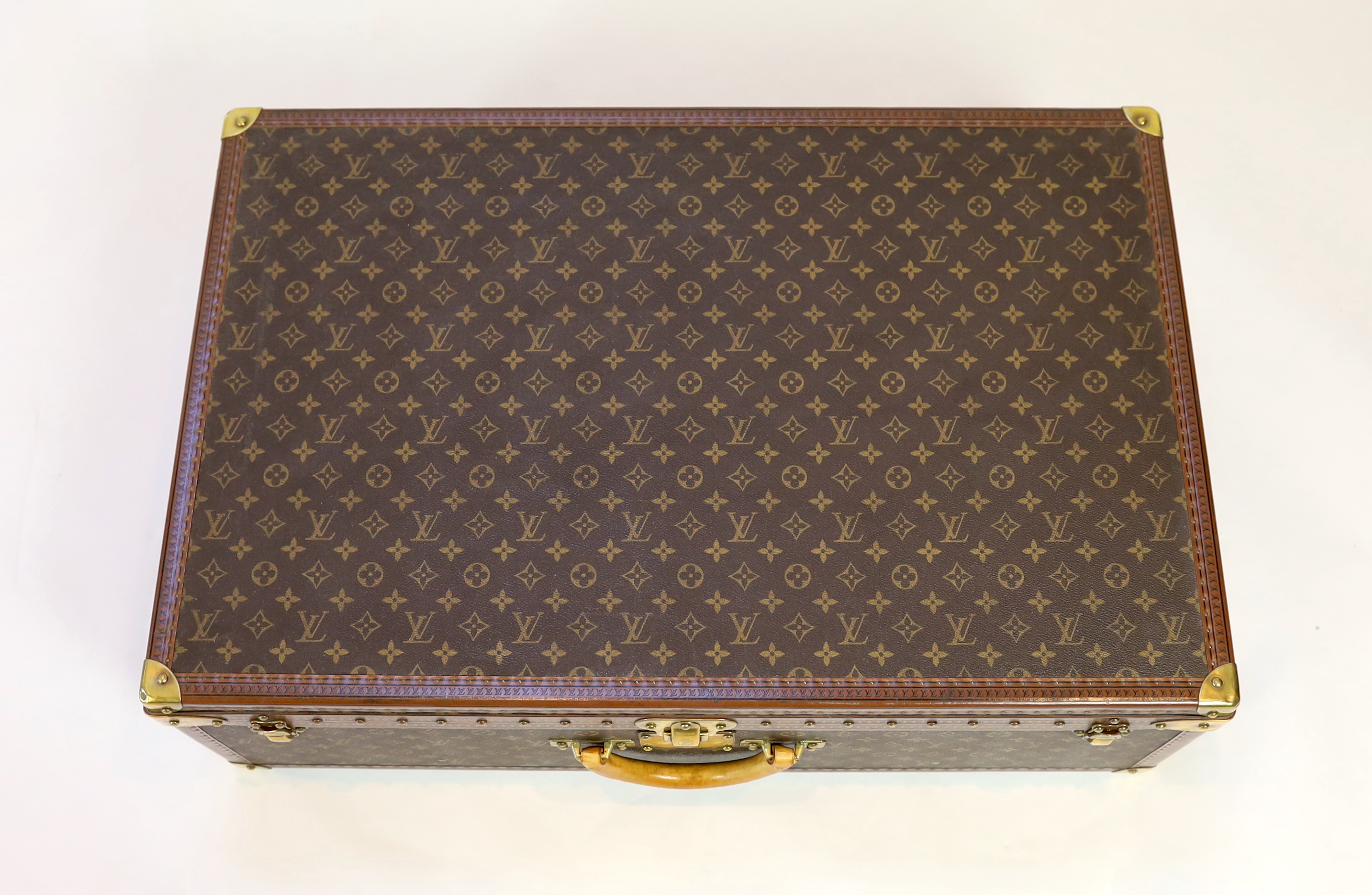 A Louis Vuitton monogrammed canvas and tan leather suitcase, 81cm wide, 26cm deep, 52cm high